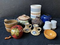 Front view showing the full collection including pot, shakers, candle holders, bowls, bell, and vase.