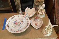 Cake plate with matching cake server and assorted porcelain figurines including Lenox swan and Capodimonte music box.