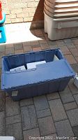 Blue plastic storage bin containing the collection items.