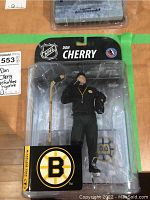 Front view of Don Cherry McFarlane NHL figurine in original packaging, showing figure with black tracksuit and hockey stick.