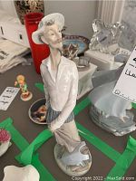 Front view of the Lladro porcelain figurine showing the man's face, hat, and pose with hands behind back.