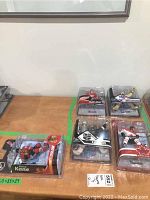 Five NHL McFarlane figurines displayed on wooden surface including players Patrick Kane, Jonathan Quick, Pavel Datsyuk, and two others in original packaging.