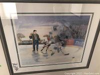 Front-facing photo of the framed James Lumbers hockey print showing the hockey scene and signature.