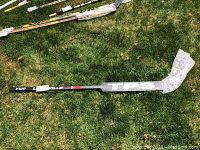 Full length shot of the TPS hockey stick laying on the grass, bubble wrapped on the blade and shaft sections.
