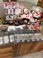 Full display of all items including signed Beanie Boppers, hockey pucks, cards, tickets, key ring, and unopened mini plaques arranged on a table.