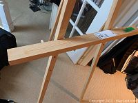 Photo of the easel showing its full support beam and wood grain texture.