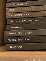 Stack of photography books spines showing titles such as 'Great Photographers', 'Color', 'Photographing Nature', 'Caring for Photographs', 'The Camera', 'Frontiers of Photography', and 'Photographing Children'.