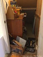 Closet view showing multiple boxes, toolboxes, and containers filled with tools and materials