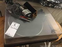 Full view of turntable under clear dust cover with seller tag labeled 'Turntable'.