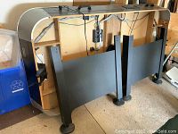 Full view of the Sportcraft air hockey table frame with legs removed, showing black playing surface attached to the metallic silver frame with wiring visible underneath.