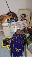 Wide view of the variety of decorative trays, whiskey bags, and some memorabilia items arranged on floor