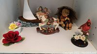 Overview of all figurines and floral decorations including Umbrella Boy, rocking horse, sailboat, cardinal, and flower ornaments.