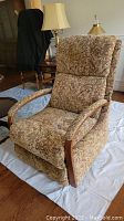 Angle showing side and front views of La-Z-Boy manual recliner chair with patterned fabric upholstery, wooden armrest accents, and padded arms.