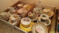 Overall view of ten teacup and saucer sets and two creamers in cardboard box