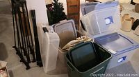 Six translucent Vision 80L storage totes with blue flip lids, one Sterlite 38L under bed storage tote, two Rubbermaid translucent storage totes, some stacked with lids on, set on carpeted floor.