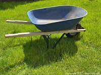 Side angle showing deep blue metal bucket with wooden handles and wheel.