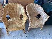 Front view of two vintage wicker chairs side by side on concrete floor