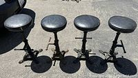 All four stools grouped together outdoors, showing overall condition and matching style