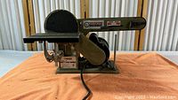 Side view of the Central Machinery belt and disc sander combination showing the belt sander on the right with tension adjustment handle and disc sander on the left with work support platform.