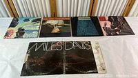 Five 12" vinyl records on display featuring Miles Davis and John Lee Hooker albums.