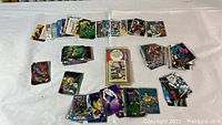 Photo showing multiple stacks of Marvel comic cards and Upper Deck baseball cards spread out, various characters and players visible.