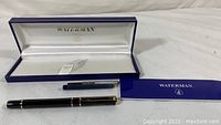 Photo of Waterman blue presentation box open with black fountain pen and blue ink cartridge inside