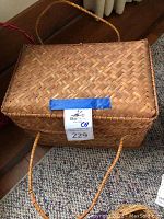 Closed rectangular covered woven picnic basket with handles