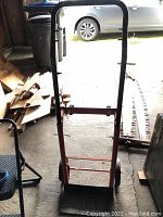 Front view of metal dolly and 2 step ladder showing the handles and base plates