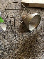 Metal food mill with wire stand placed on carpet floor