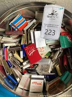 Metal tin filled with an assortment of vintage matchbooks from various defunct restaurants and establishments.