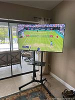 Front view of 55-inch Samsung TV on adjustable stand showing screen and stand base