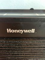 Close up of Honeywell branding on black air purifier surface with dust shown