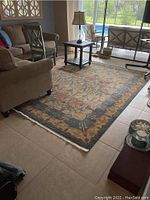 Full view of the large rectangular area rug placed on tile flooring in living room with furniture around it.