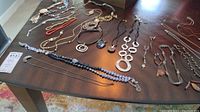 Multiple necklaces laid out on table showing different styles including beaded, metal disc and leather cord necklaces