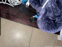 Close up of dark blue Naipo massager blanket with some white cords and power plugs around it