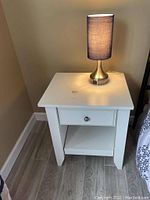 White nightstand with single drawer and open shelf at the bottom