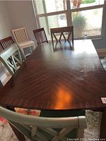 Top view showing rectangular wooden dining table surface with scratches and chairs around it.