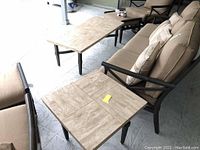 Photo showing both the rectangular patio coffee table and the square side table in a porch setting with cushioned patio seating.