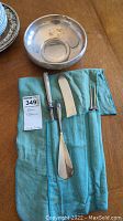 Sterling silver bowl shown with four-piece utensil set in blue-green pouch, includes fork, knife, large and small spoon