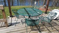 Overview of green metal mesh table and four chairs on deck