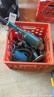 Multiple power tools including Makita and Ryobi angle grinders plus a finishing sander in a red plastic crate