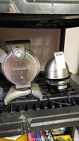 View of the Cuisinart waffle maker and egg cooker placed side by side on a shelf.