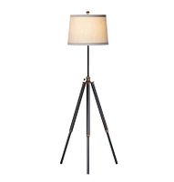 Full view of the tripod floor lamp showing the beige fabric drum lampshade and black metal legs with bronze accents.
