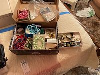 Wide view of shoebox with multiple small boxes of jewelry and two bags showing overall contents