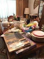 View of cutlery set on wooden board, assorted napkins, dinner plates, and decorative items on table