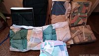 Photo showing seven boxes containing assorted folded towels in various colors including green, blue, beige, and pastel stripes.