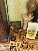 Wide view showing goddess porcelain sculpture, eagle sculpture, framed Asian art, framed landscape art, wooden plates, pedestal with Asian vase on top