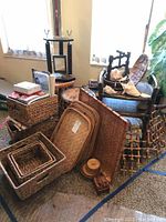 Grouped view showing 4 small bamboo tables, stack of wicker trays, nesting baskets, and decorative items including shells and small wooden boxes.