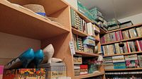 Shelves filled with multiple shoe boxes and pairs of shoes visible including a pair of turquoise heels and cream heels