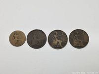 Four antique bronze coins laid out in a row showing the reverse design with seated Britannia and denominations.